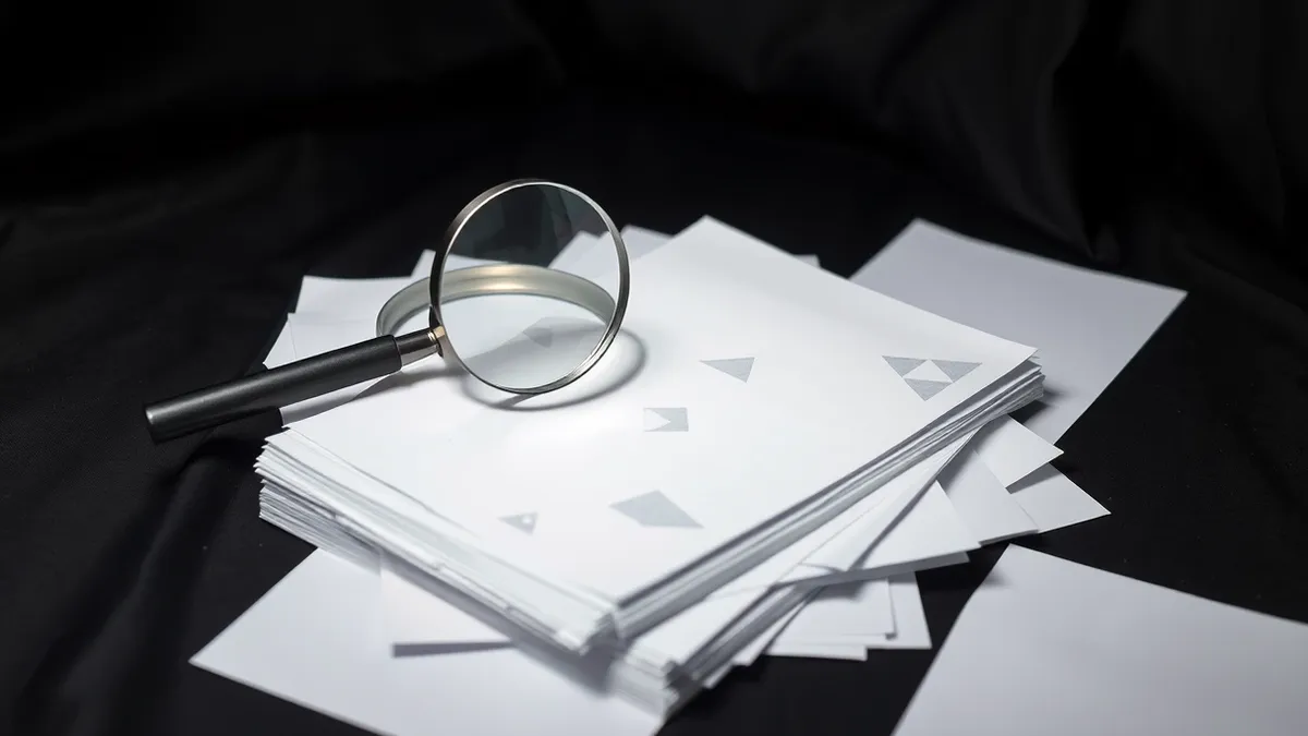 Illustration: A thick stack of blank white paper lies scattered across a clean desk.